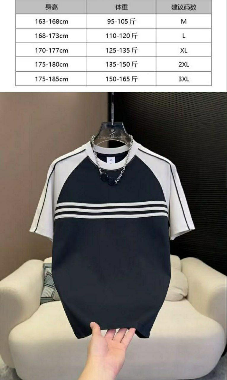 T-shirt de style raglan avec des manches blanches et un corps noir orné de trois rayures horizontales blanches.