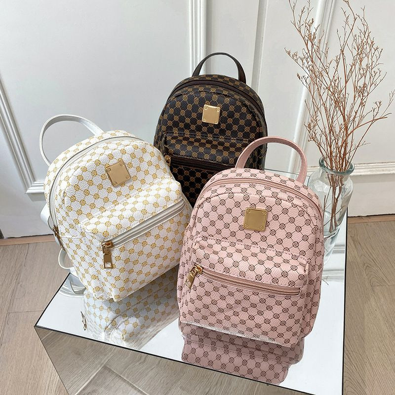 Mini-sacs à dos pour femmes en cuir PU sont disponibles en trois couleurs avec un motif imprimé classique et une plaque dorée.